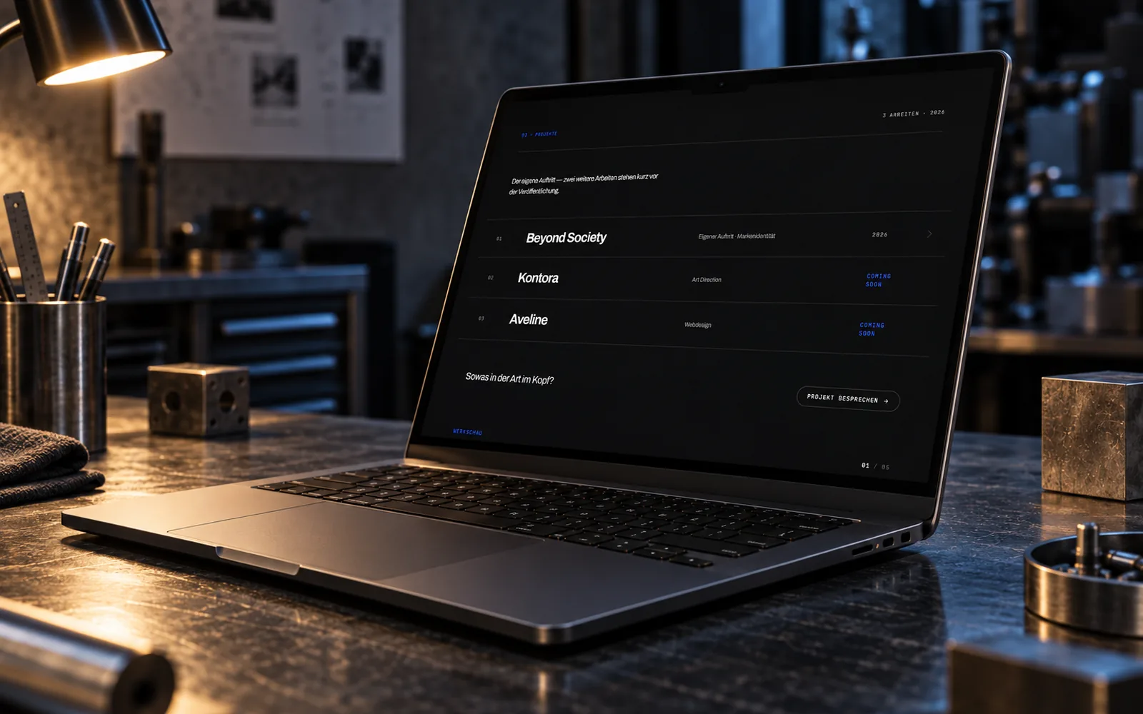Laptop unter einer Leuchte, auf dem Bildschirm die Projektliste