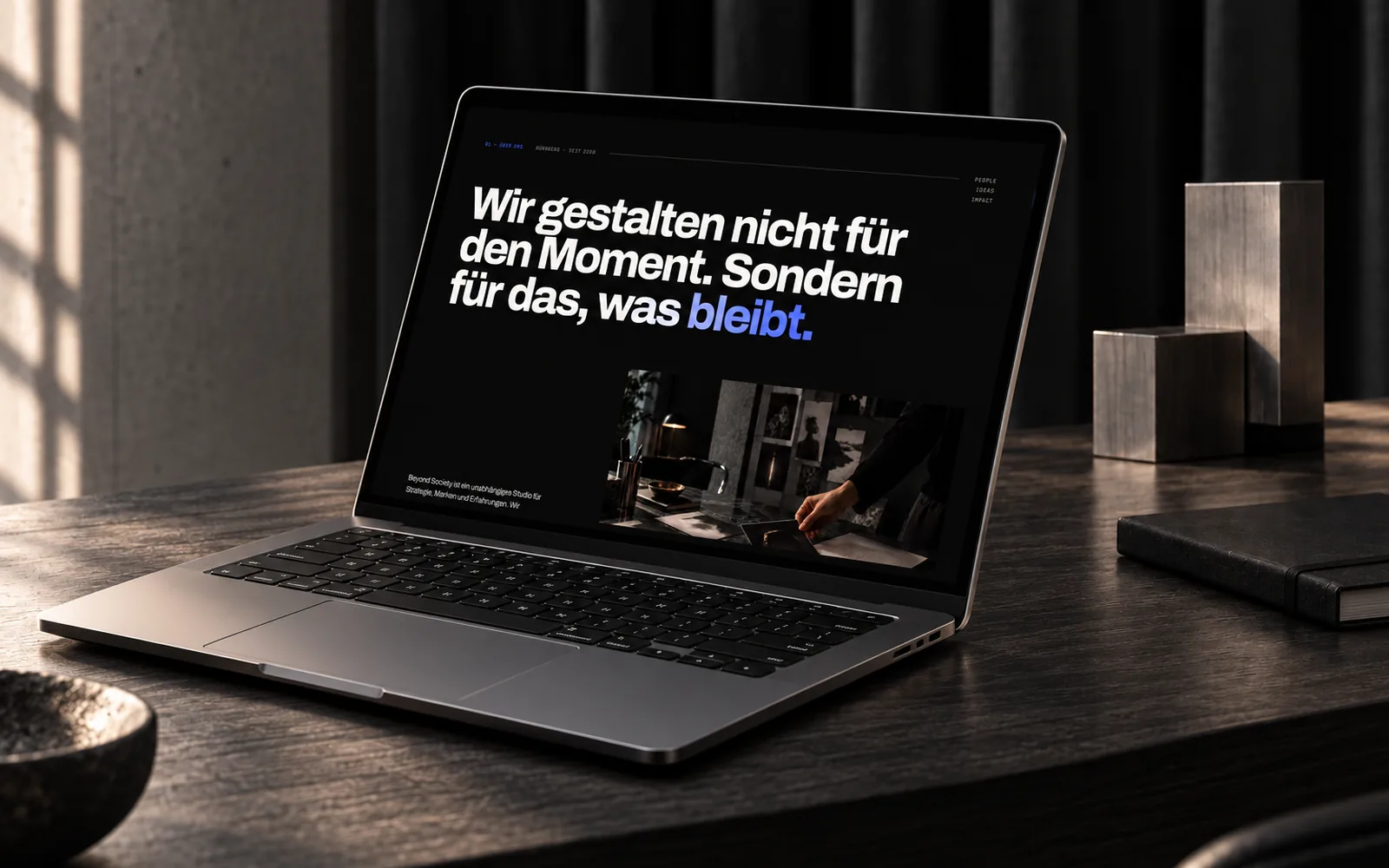 Laptop auf einem Steintisch, auf dem Bildschirm der Abschnitt Über uns