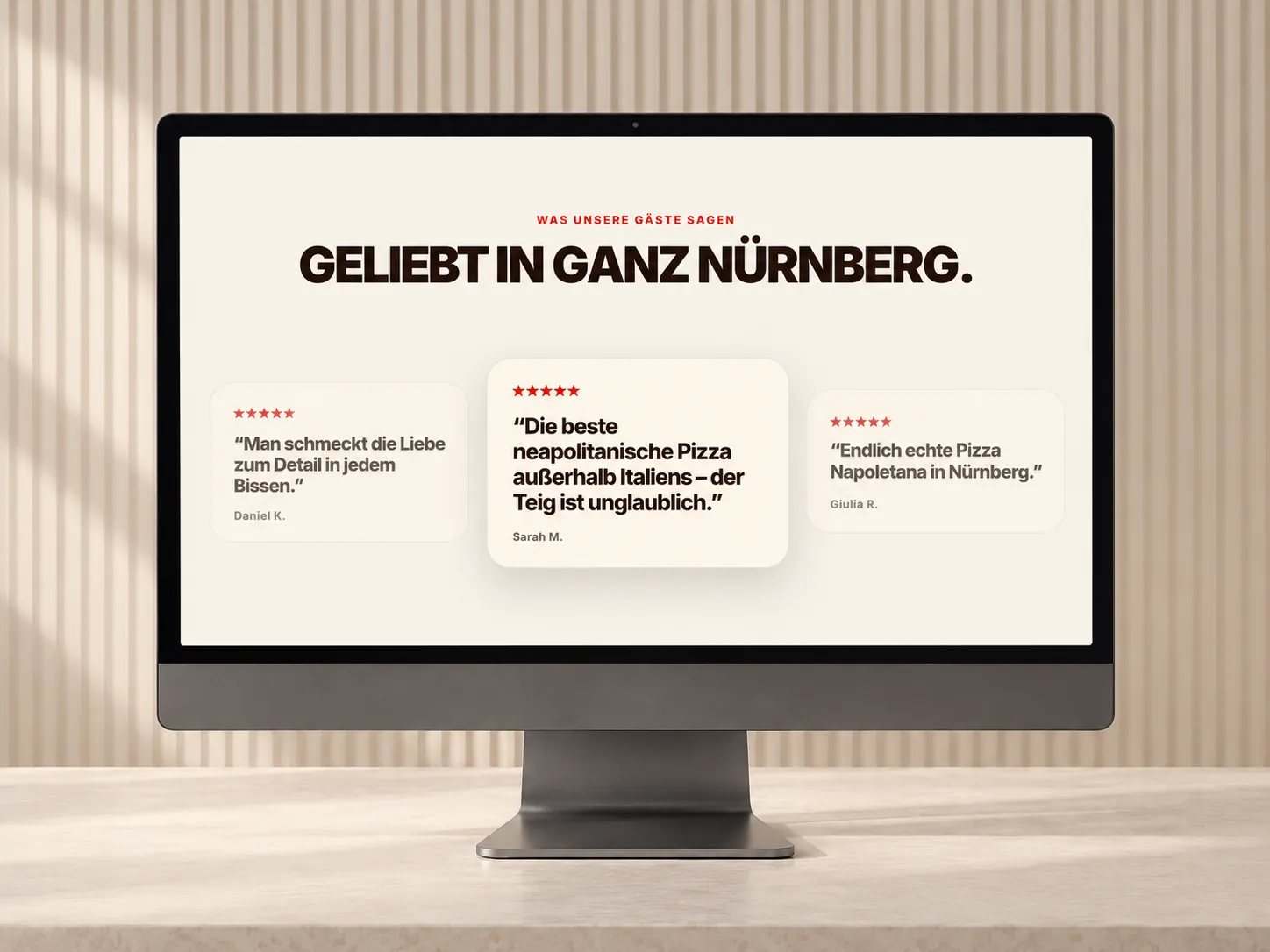 Monitor vor einer hellen Lamellenwand, auf dem Bildschirm Geliebt in ganz Nürnberg mit drei Gästebewertungen