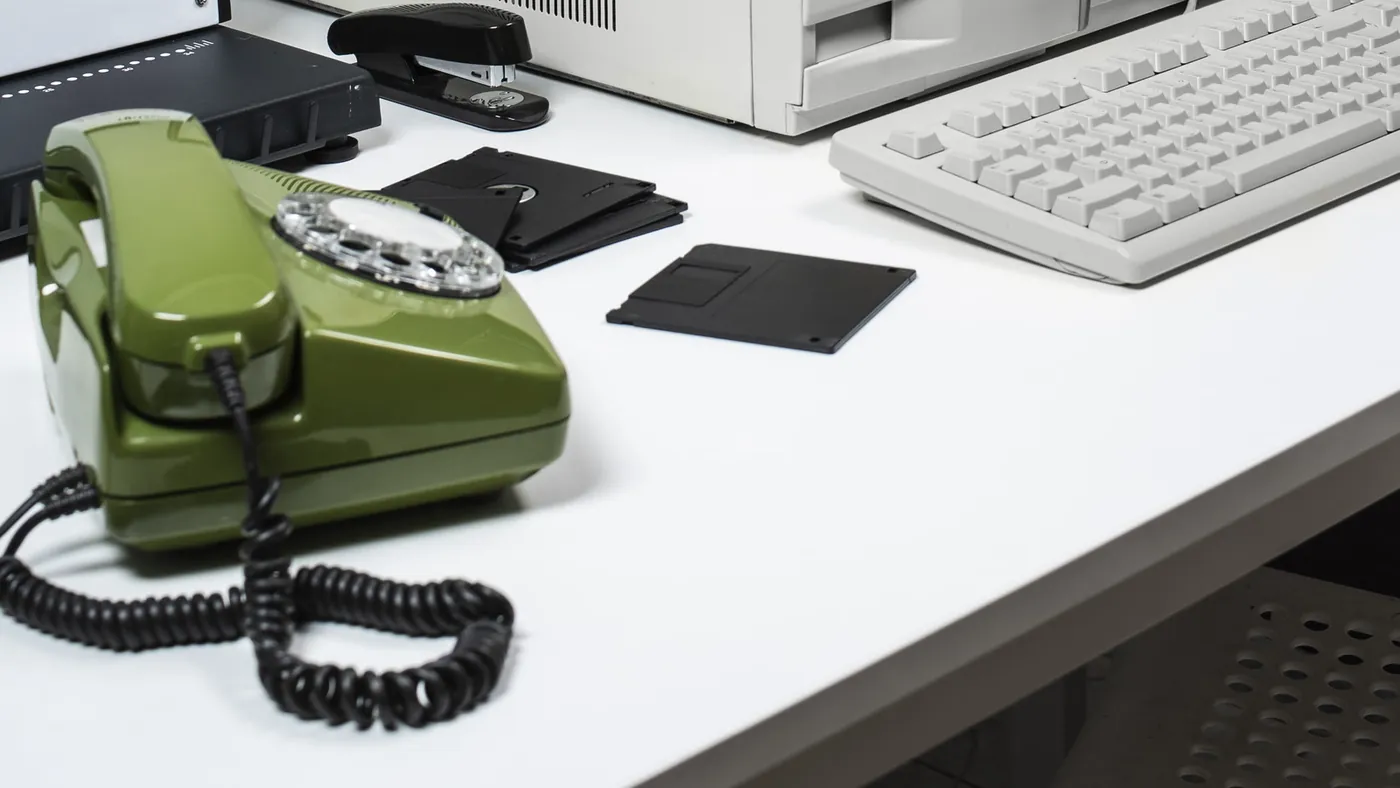 Schreibtisch mit Tastatur und Telefon im Halbdunkel